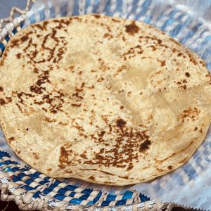 A tortilla sitting on top of a blue and white plate.