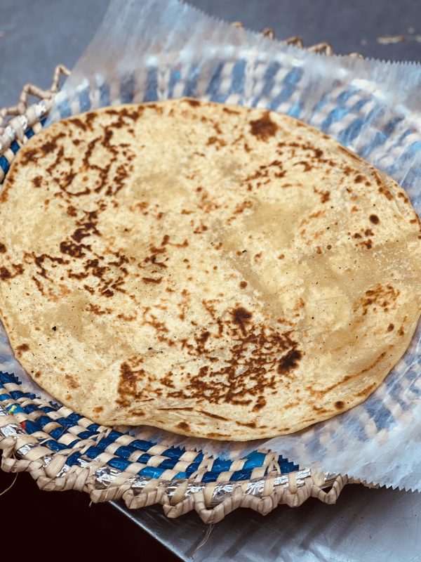 A tortilla sitting on top of a blue and white plate.