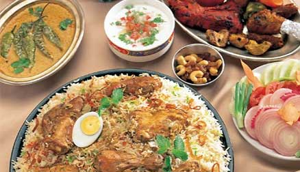 A table with rice, meat and other food items.