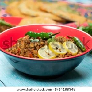 A bowl of food with meat and vegetables.