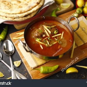 A bowl of soup on top of a wooden board.