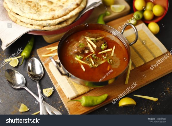 A bowl of soup on top of a wooden board.