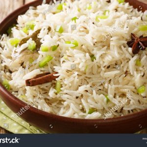 A bowl of rice with cinnamon sticks in it.