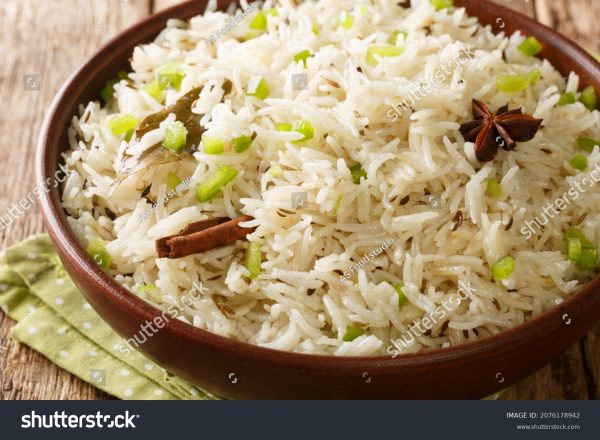 A bowl of rice with cinnamon sticks in it.