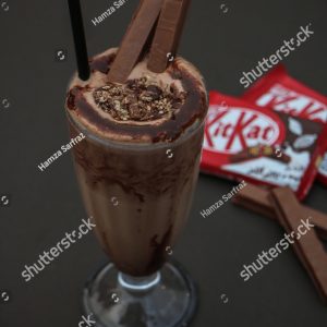 A chocolate milkshake with a straw in it