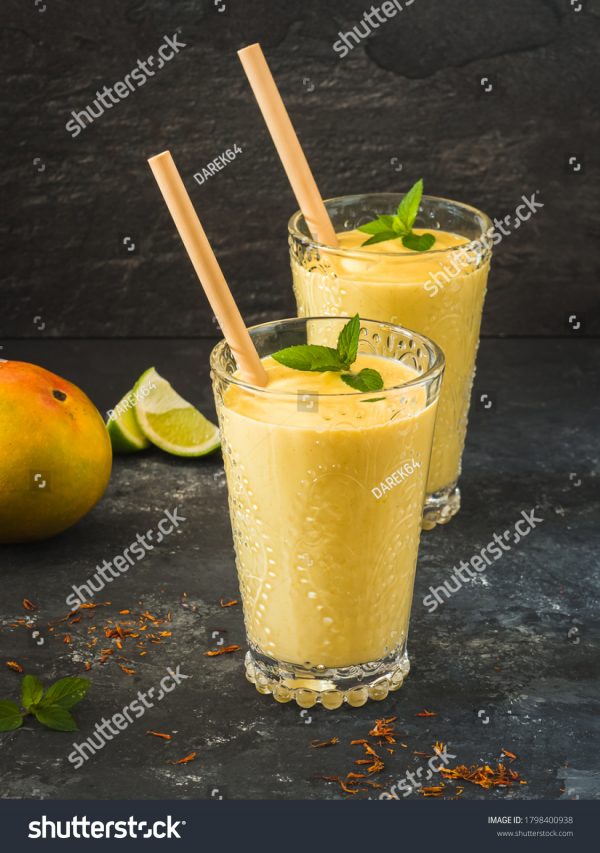 Two glasses of orange juice with a straw in them