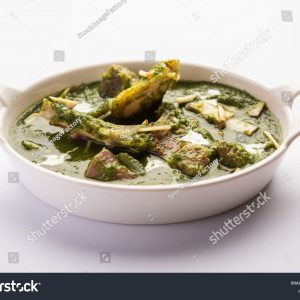 A bowl of food with some type of green sauce.