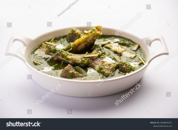 A bowl of food with some type of green sauce.